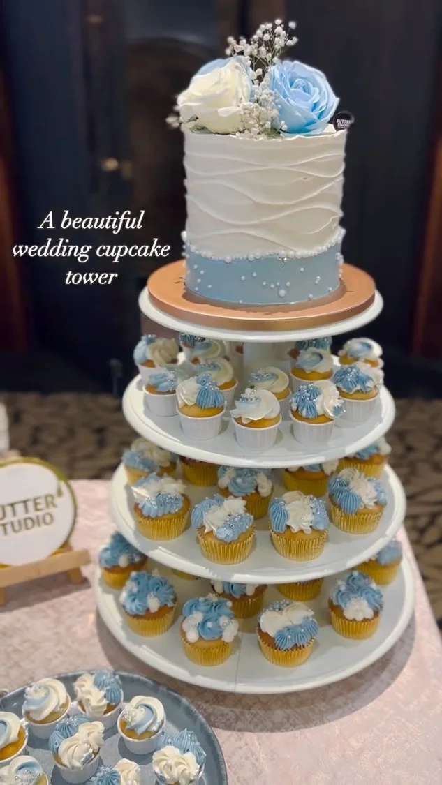 Tiered blue wedding cake with matching cupcakes