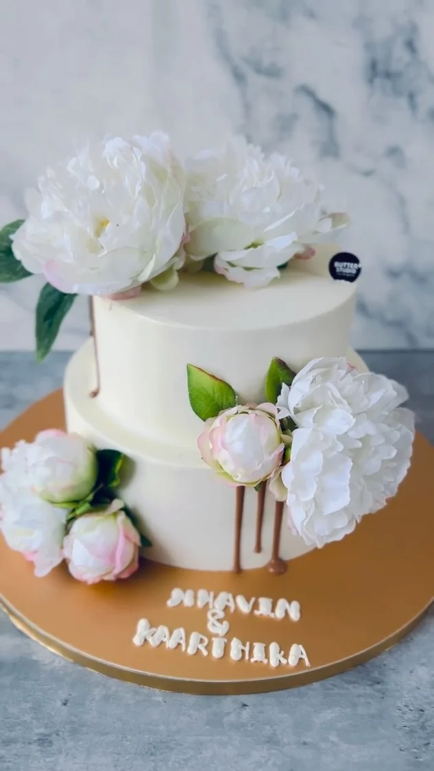 White floral cake with small gift boxes