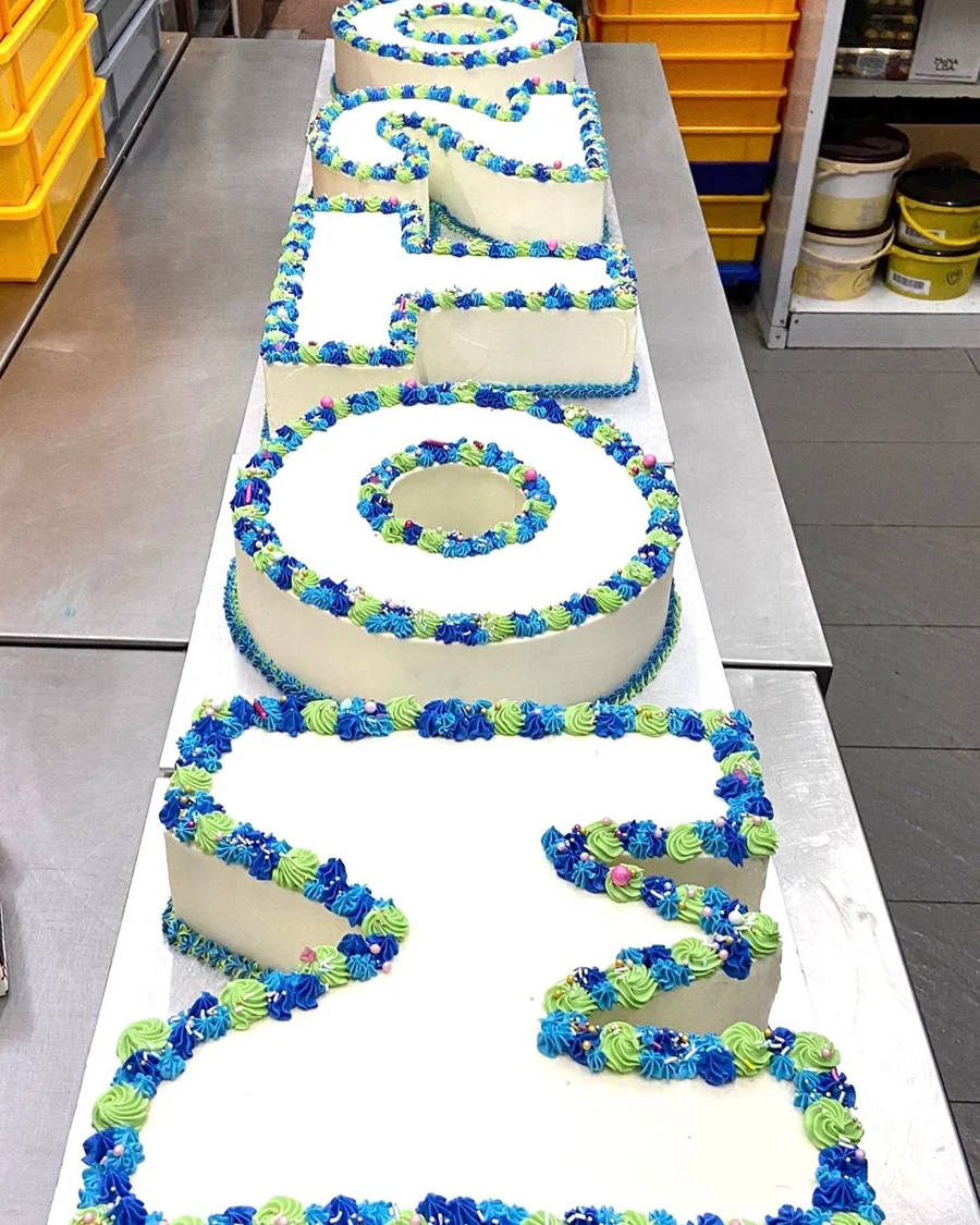 Large rectangular celebration cake with blue decorations
